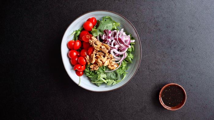 príklad šalátu zo špenátovej rukoly vlašských orechov cibule a cherry paradajok vinaigrette na vloženie do letného šalátu