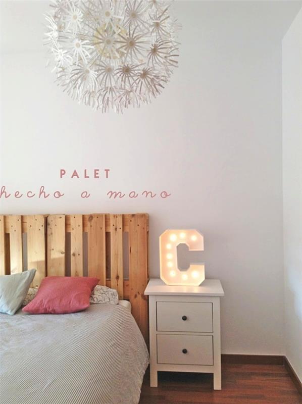 لوح أمامي ، غرفة نوم بيضاء مع أرضيات خشبية وسرير مزدوج مزين بوسائد باللونين الوردي والأزرق