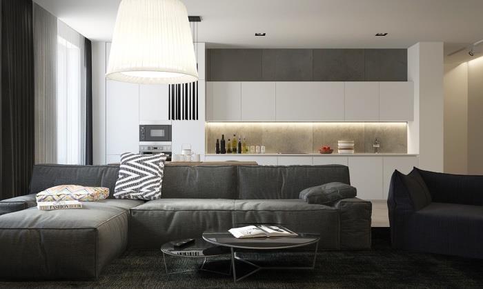 passa in ett litet kök öppet för vardagsrum, vit köksfasad och grå stänk, öppning mot vardagsrum med soffa och antracitgrå matta, svart häckande soffbord