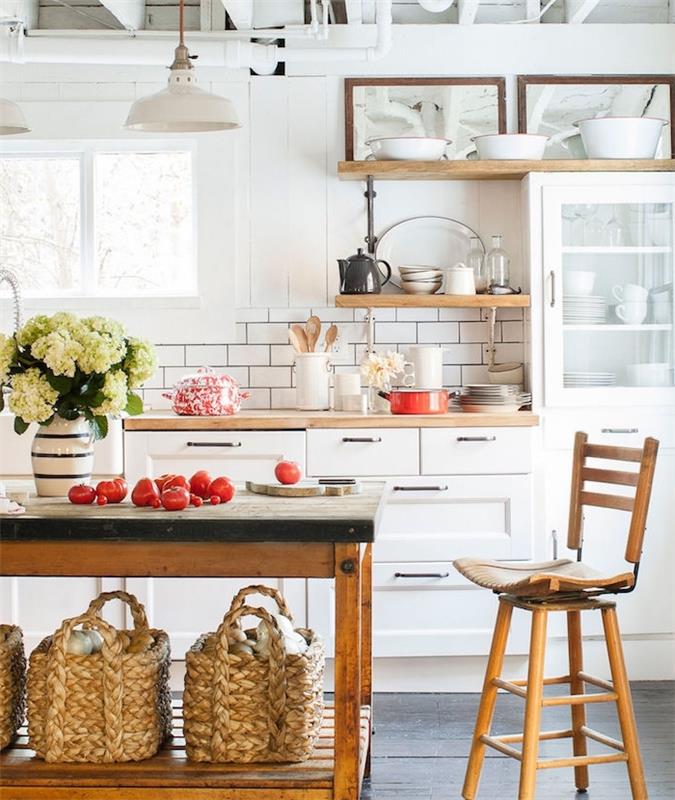 تصميم مطبخ ريفي أنيق مع خزانة مطبخ أمامية بيضاء ، ورفوف خشبية صغيرة ، وجزيرة طاولة عمل خشبية عتيقة ، وديكور زهور وخضروات