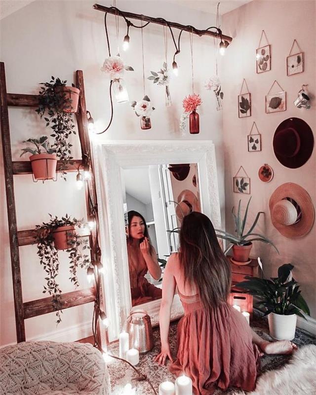 Dievča sa pozerá na seba v zrkadle a robí si makeup, ružové šaty, rebrík na ukladanie kvetov, listy v rámoch
