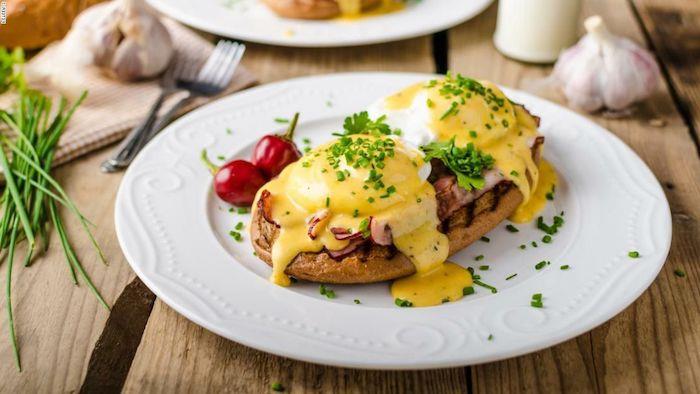 uvarte recept na brunch z vajíčka benedikt podávaný so slaninou a holandskou omáčkou na tanieri posypanom petržlenovou vňaťou