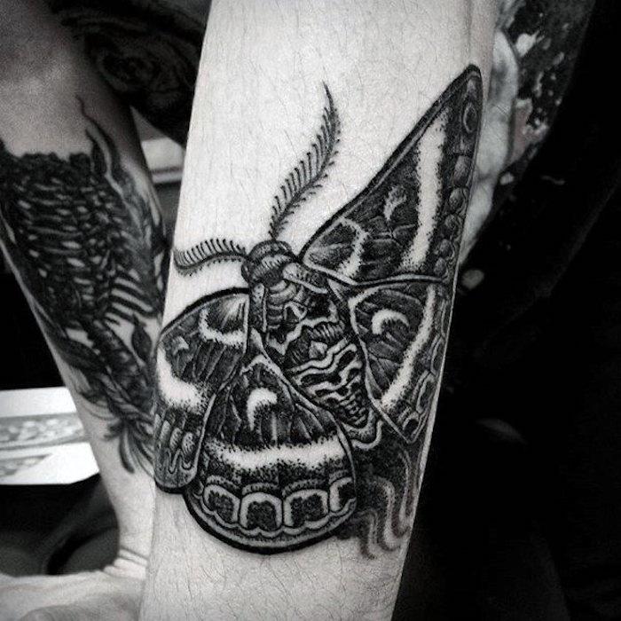Il braccio di un uomo con piccolo tatuaggio di una farfalla