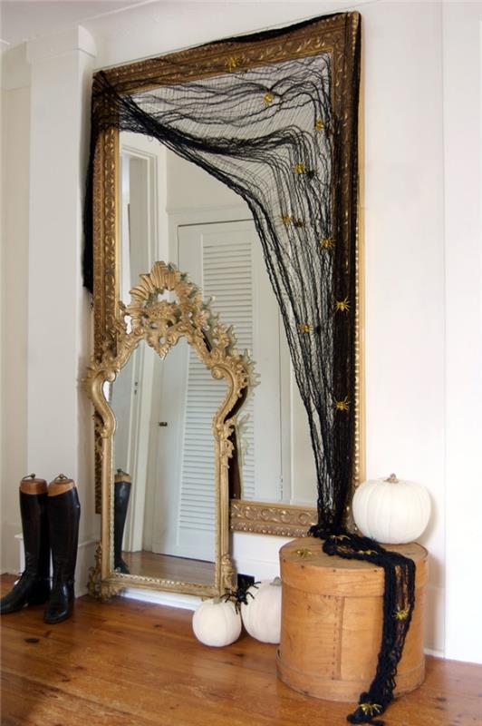 manuell halloweenaktivitet, sovrumsinredning med stor spegel med gyllene ram täckt med svart tyg som spindelnät
