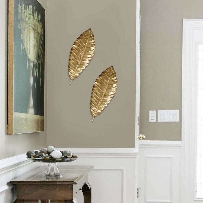 idé hur man ordnar en hall med taupe och vita väggar med en dekorativ bit med en guldfinish i form av målning och löv