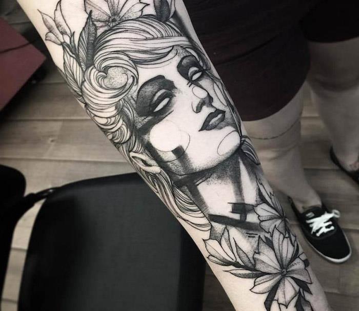 mans underarmstatuering med tatuerad kvinna, kvinnans huvud omgiven av blommor