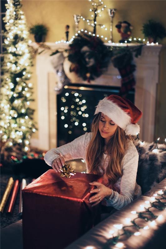 Fotografia zámku smartfónu s vianočnou tematikou, veselý vianočný obrázok s dievčaťom vo svetlej zdobenej obývačke