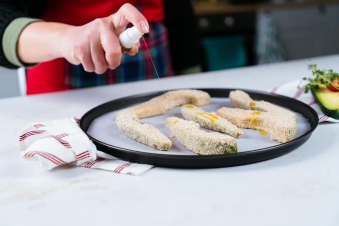 avokadoskivor arrangerade på pappersfodrade bakplåtar, besprutade med olja, fingermatsrecept