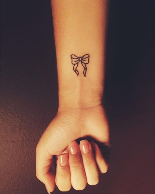 Tatuaggi avambraccio, tattoo disegno fiocco, donna con mano tatuata