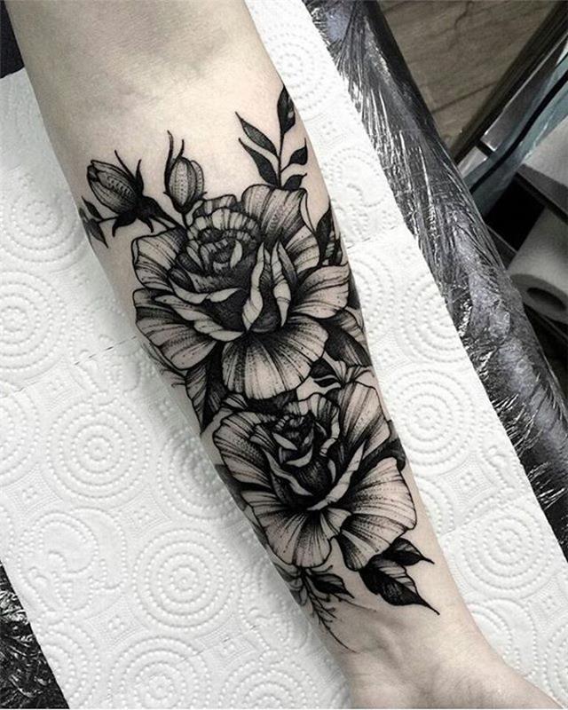 Tattoo old school braccio con il disegno floreale sull'avambraccio di una donna