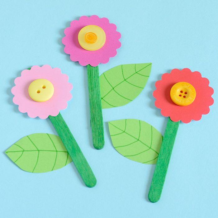 kvet v zmrzlinovej tyčinke, listy papiera a farebný papierový kvet so stredom žltého gombíka, remeslá v materskej škole