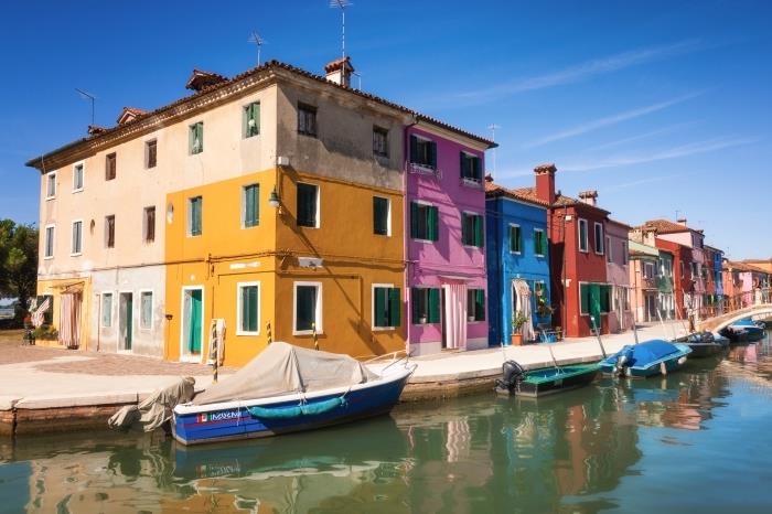 التقط صورًا رائعة أثناء رحلاته ، وورق حائط جميل مع منازل ملونة وقارب في قناة مائية