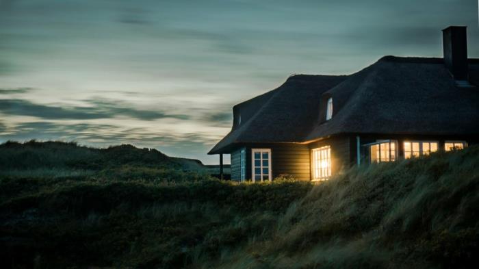 ett hus i amerikansk stil på ängen, himlen med gröna nyanser, mycket högt gräs, fönster upplysta på ett mystiskt sätt, paradisiskt landskap