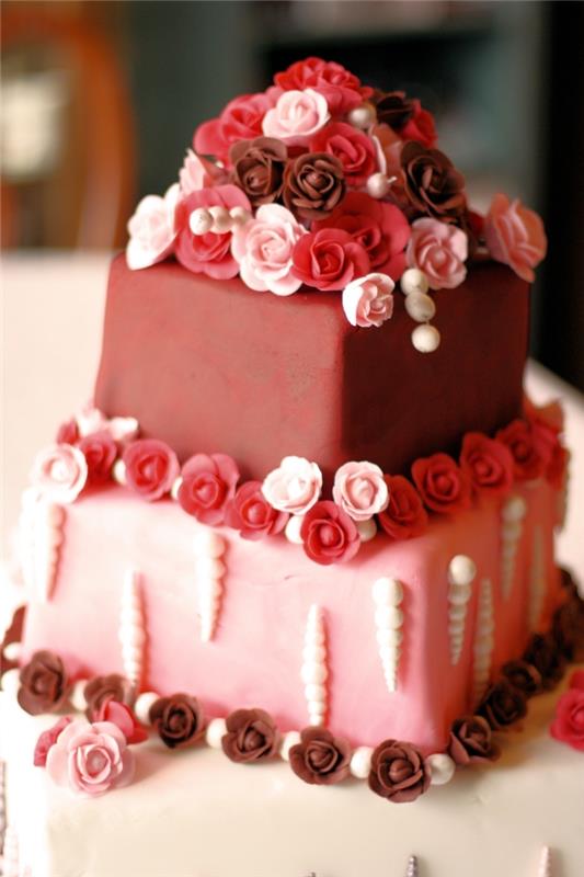 príklad domáceho valentínskeho koláča s vanilkovým piškótovým koláčom a ozdobou z červeného a ružového fondánu s malými jedlými kvetmi
