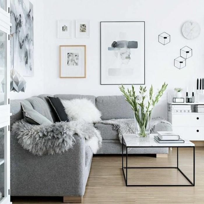 soffbord i marmor, grå hörnsoffa, ljusgrå väggar, inramad hängkonst, stor glasvas