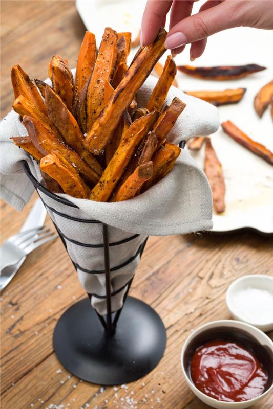 sötpotatis, pommes frites, i en metallkon, grönsaksrätt, ketchup i en vit skål