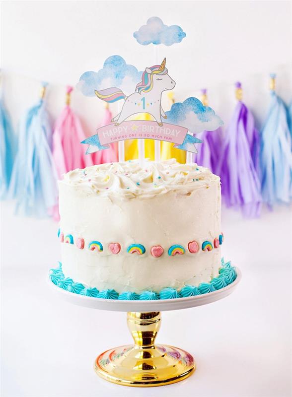 söt 1 -årig enhörningskaka med personlig tårta och regnbågsgodis på sidorna