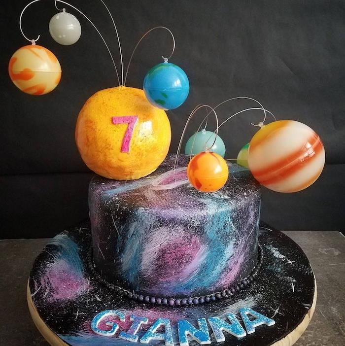 model dievčenskej narodeninovej torty s nejedlými planétami a originálnou čiernou polevou s modrými, ružovými a bielymi mrakmi