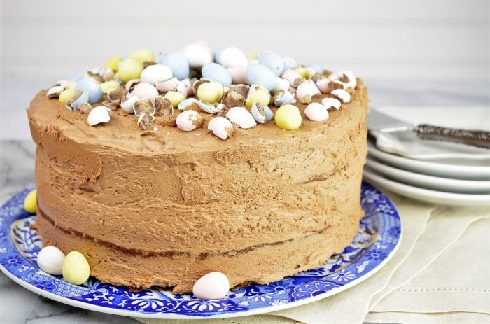 en mjölkchokladkaka med påsktema, kakaosvampkaka täckt med smörkräm och choklad dekorerad med choklad påskägg