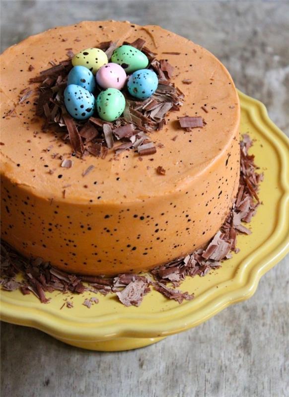 traditionell påskboxtårta med prickig smörkräm och chokladglasyr med ett litet bo med chokladspån och påskägg