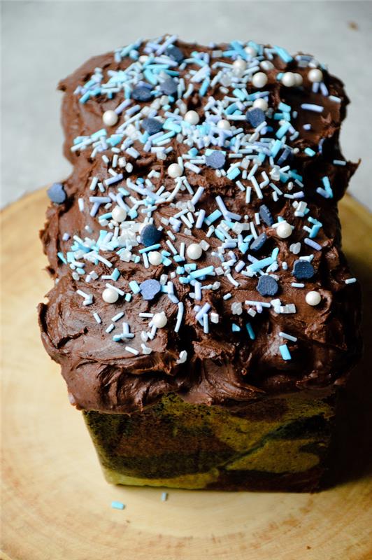 malá torta na narodeninové čokoládové občerstvenie s čokoládovou polevou a guličkami a posýpkou z modrého a bieleho cukru
