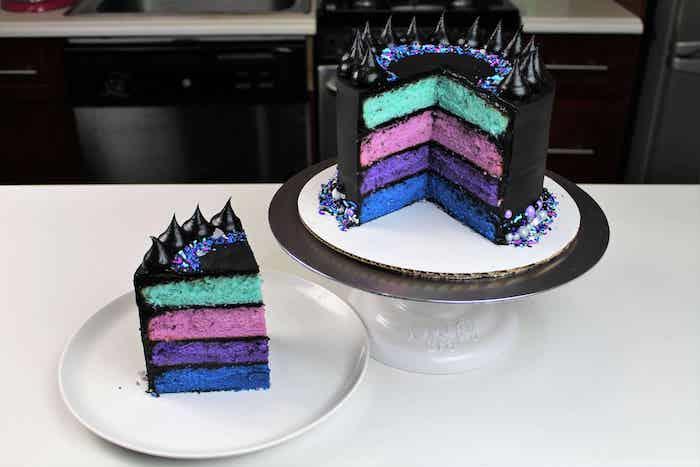 originálna plienková torta s farebnými piškótovými vrstvami v zelenej, ružovej, fialovej a modrej a čiernej krémovej poleve