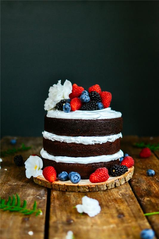 fotka domácej narodeninovej torty, peknej torty zdobenej červeným ovocím a bielymi kvetmi