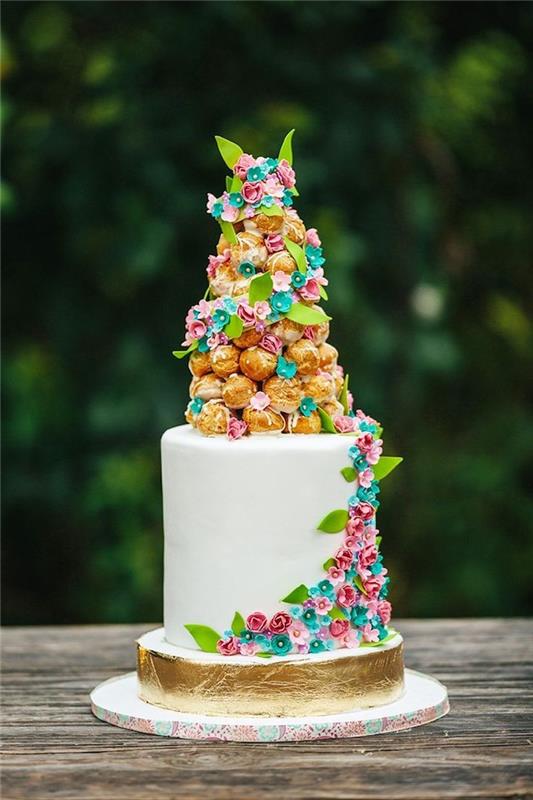 tårta dekorerad med en bröllopstårta med ljus och små sockerpastablommor och gyllene bas