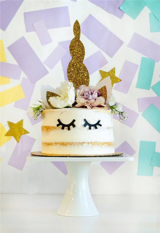 söt enhörningskaka naken tårta dekorerad med enhörningstillbehör och en vägg av konfetti i bakgrunden