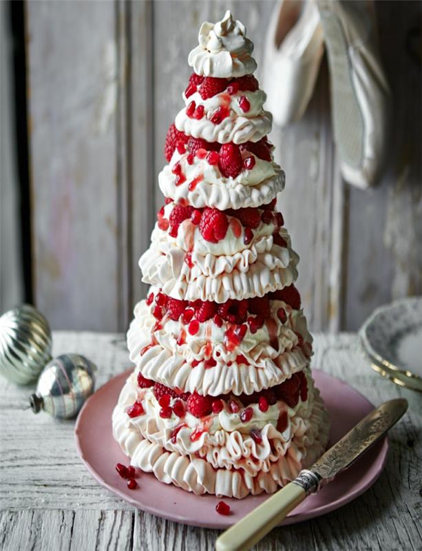 pekná veža z bieleho krému a červeného ovocia, ružový tanier, vianočné hračky