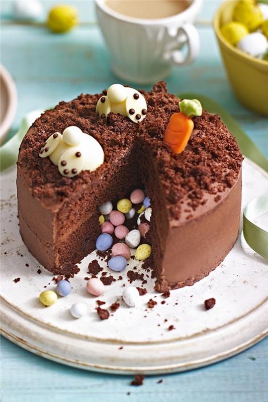 choklad pinatatårta dekorerad till påsk med två kaniner i marsipan med huvuden doppade i kakan