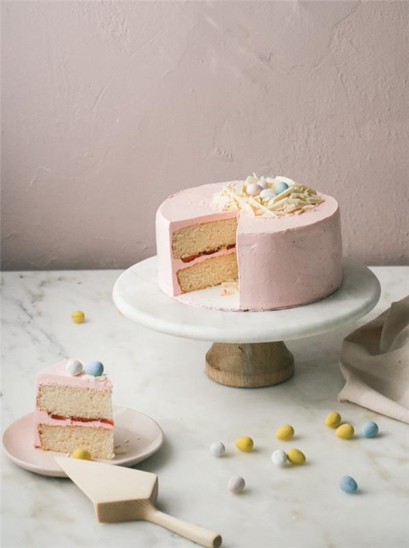 dessertidéer för påsk, traditionell vanilj- och jordgubbs påskkaka toppad med rosa smörkräm med vit chokladbo
