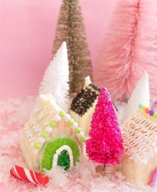 Nyår och juldessert, små pepparkakshus dekorerade med vit choklad, kunglig glasyr och gummier till dörren, konstgjord julgransdekoration