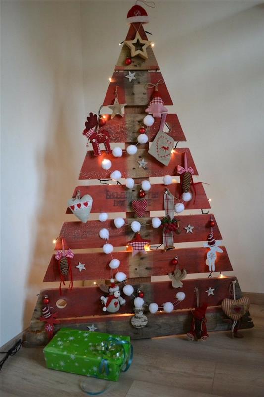 Vianočný stromček z drevených dosiek, trojuholníkového tvaru vytvoreného z paliet, girlandy z pomponov, jeleňov, srdiečok a hviezd, malých textilných figúrok