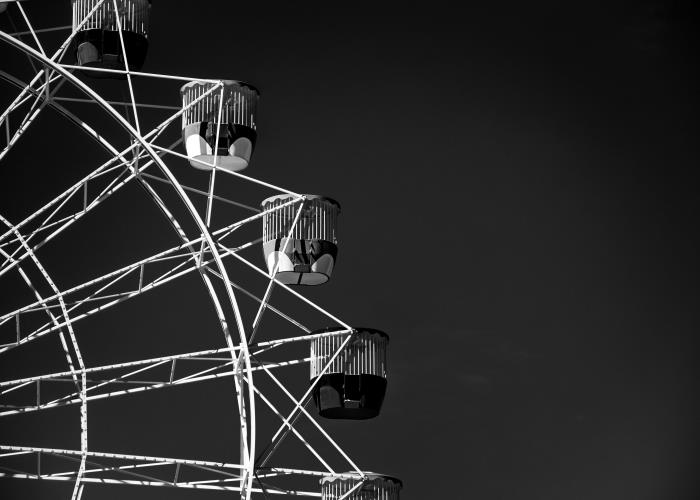 vackert konstnärligt svartvitt foto av ett gigantiskt hjul som sticker ut mot bakgrunden av den svarta himlen, svartvit fotografering