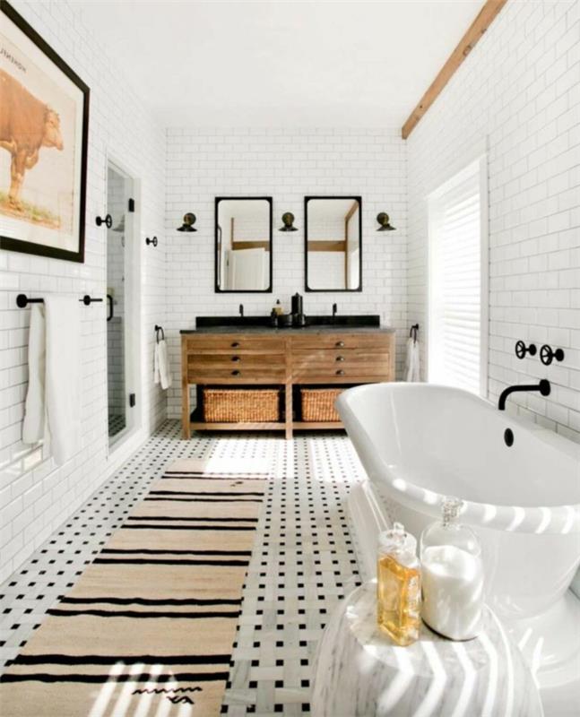 vackert badrum, beige matta med svarta ränder, slitna fåfänga i trä, vita väggplattor, stort inramat fotografi