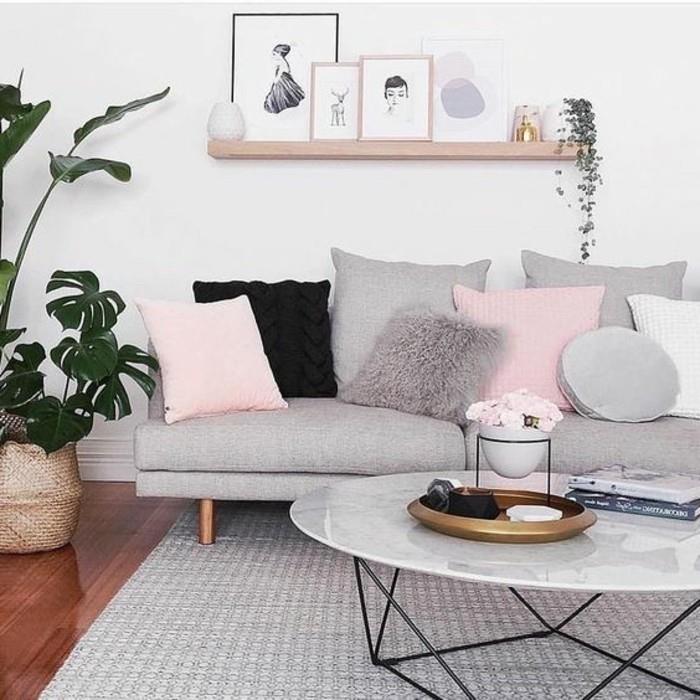 grå soffa, rosa kuddar, soffbord i marmor, hängande trähylla, gråa vardagsrumsväggar