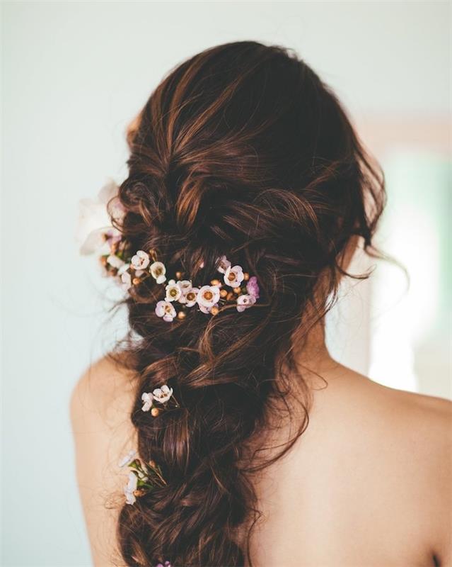 voluminös kvinna fläta med dekoration av små blommor, fria trådar, bohemisk rufsig stil