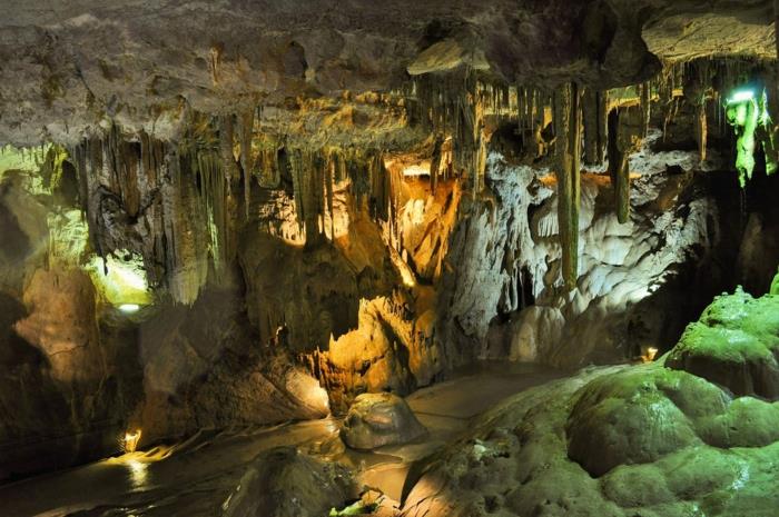 vackert landskap, drömlandskap, grotta med hängande stalagmiter, fuktiga grottundergångar, med gröna områden