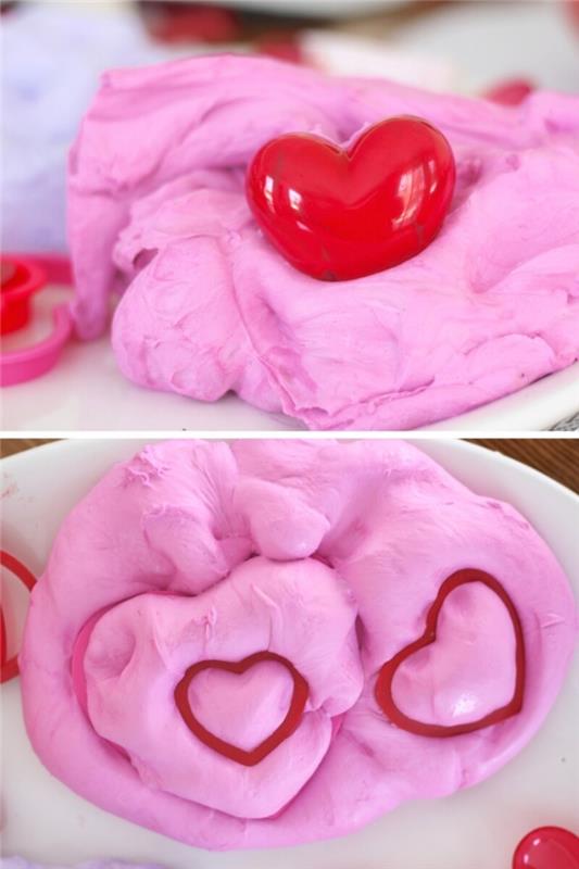 سلايم غراء ناعم ورقيق من إلمر ، يشبه حلوى القطن الوردية ، بقلب أحمر صغير من البلاستيك ، وطبعتان على شكل قلب