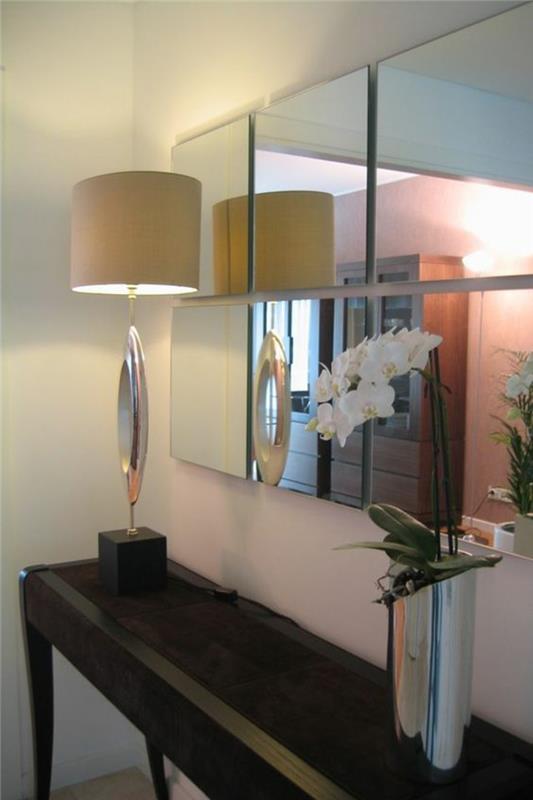 nápad na výzdobu domácej vstupnej haly s originálnou stojatou lampou a kovovou vázou striebornej farby