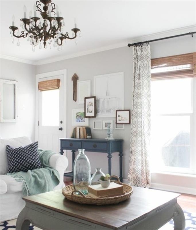 vintage soffbord i trä, vit soffa, vackra vardagsrum, vita väggar, hängande ljuskrona