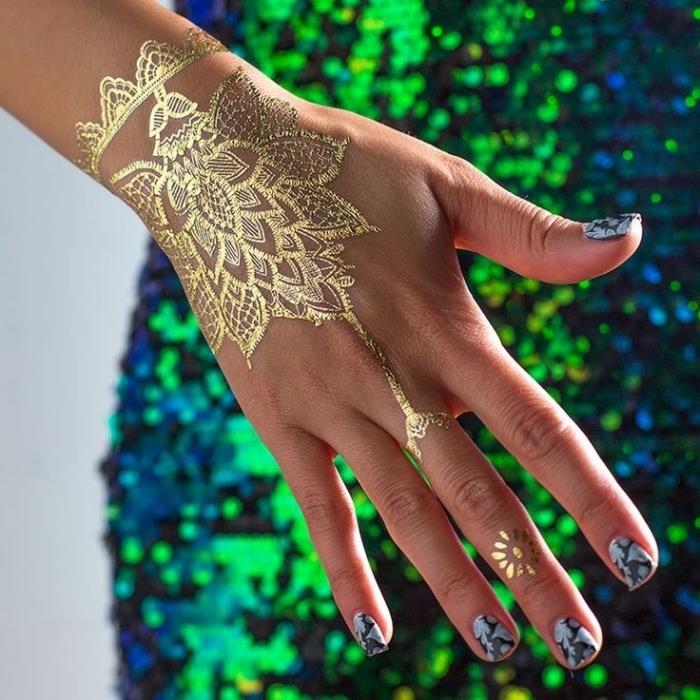 Tatuaggio sul dito e un'idea con Henna tatto in oro sulla mano di una donna