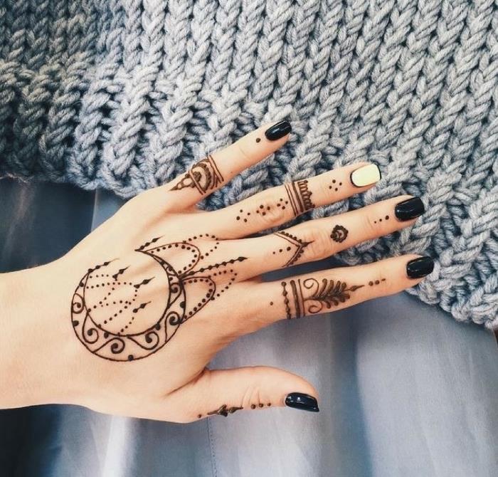 Tatuaggi sulle mani e un'idea con un tattoo Henna di una donna con smalto bianco e nero