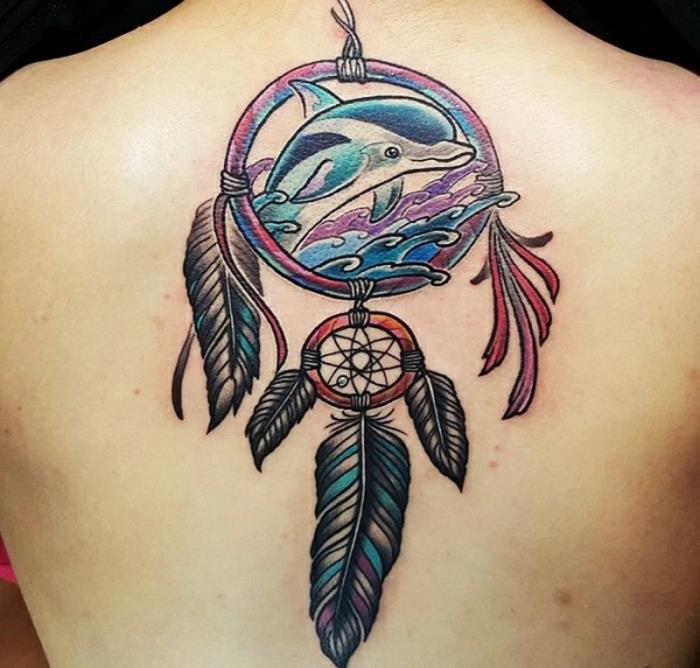 drömfångsttatuering på baksidan, stor båge med en delfin inuti, havsvågor, fjädrar i mauveblått och svart