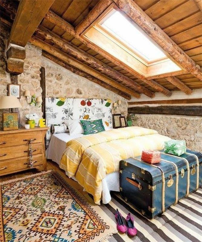 stenväggar, mångfärgad säng och sänggavel, randig matta, blå stammsäng, orientalisk matta, vintage träskåp, gult sängklädsel, synliga balkar, inredning