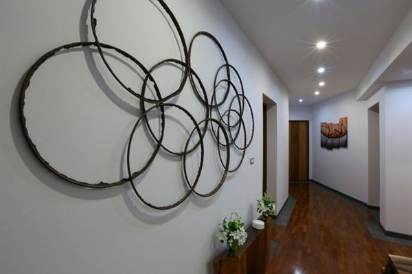 dekorativ-korridor-idé-vägg-installation-med-ringar-liten-hylla-med-blommor