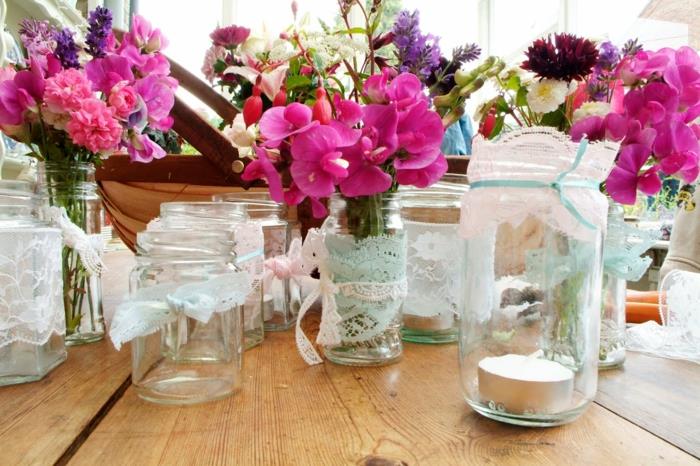 bröllopsdekoridé, personliga glasburkar med spetsar, ljusstakar och blomkrukor fyllda med buketter