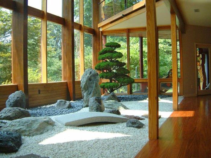 حديقة زن داخل إطار منزل من الخشب والحصى والحصى والحجارة وتقليد الجبال والشجرة اليابانية والنوافذ الكبيرة
