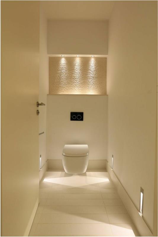 dekor toaletného krému, biely záchod, zapustené reflektory nad nástenný výklenok